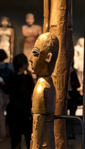 a close-up side view of the smaller Tel el-Farkha statue, highlighting the lapis lazuli inlaid eye.