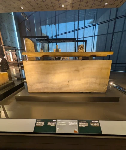 Hetepheres' alabaster sarcophagus on display in the Grand Egyptian Museum. One of the highlights of the museum, it sits under a ceiling of painted stars and has the lid held in place just above the coffin.