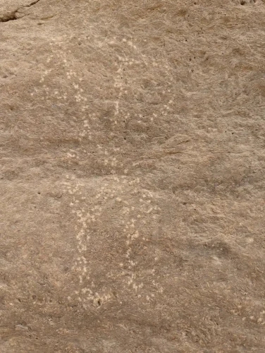 The image shows the surface of a large rock, with an imaged pecked to form the shape of a person.